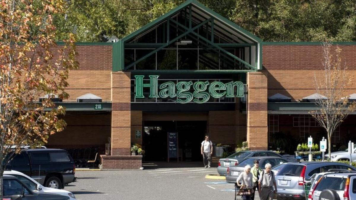 Brick storefront facade with gabled timber entry canopy at a Haggen grocery store