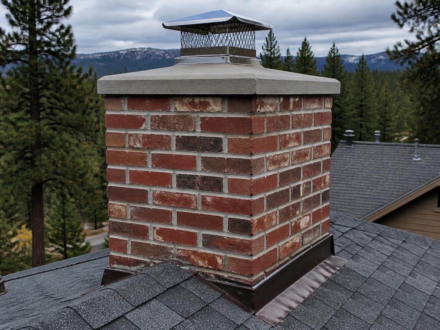 Newly built brick chimney with a cast crown and stainless cap